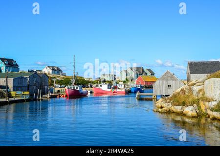 Ein malerisches Fischerdorf am Rand einer felsigen Küste. Die Lagergebäude sind rot, grün und blau gefärbt. Der Sommerhimmel ist tiefblau. Stockfoto