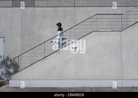 Kyoto, Japan. 7. März 2023. Ein Fensterputzer, der¬éƒ½é Kyoto Station die Treppe hinuntergeht, vorbei an einem Schild, das vor Falken warnte. Kyoto Station (ä° 2…) Wird von der West Japan Railway Company (JR West) betrieben und ist ein wichtiger Knotenpunkt für Bahnreisen in Kansai. Der Bahnhof ist gut angebunden und bietet eine breite Auswahl an Zugverbindungen, einschließlich der Hochgeschwindigkeitszüge Shinkansen, Orts- und Expresszüge sowie der JR Sagano Line und der Kintetsu Kyoto Line. Es bietet bequemen Zugang zu verschiedenen Zielen innerhalb der Präfektur Kyoto und darüber hinaus. Das Gebäude wurde vom Architekten Hiroshi Hara entworfen. Stockfoto