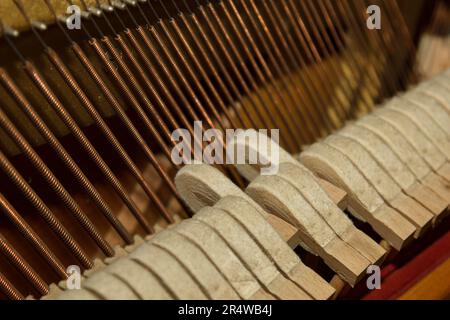 Innenteile einer alten Klaviernaht - Mechanik, Saiten. Selektiver Fokus. Details eines Musikinstruments von innen Stockfoto