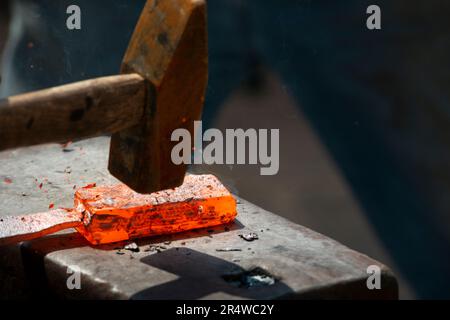 Schmied, einem glühenden Stück Eisen schmieden Stockfoto