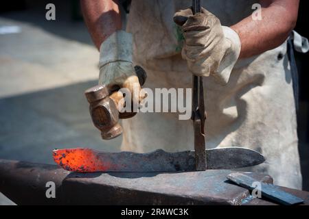 Schmied, einem glühenden Stück Eisen schmieden Stockfoto