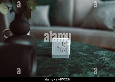 OLED-Display mit Anzeige der Temperatureinstellung der Zentralheizung bei einem drahtlosen Heizthermostat. Auf einem Wohnzimmertisch gesehen. Stockfoto