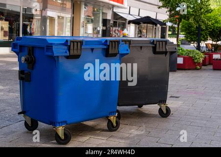 Mehrfarbige Kunststoffbehälter zum Sammeln von Müll in der Fußgängerzone der Stadt. Stockfoto