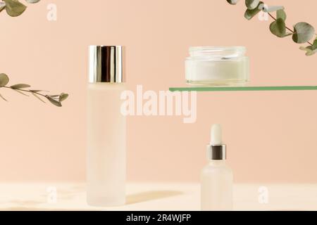 Kosmetikgläser mit natürlicher Creme, Serum und Tonic auf pinkfarbenem Hintergrund Stockfoto
