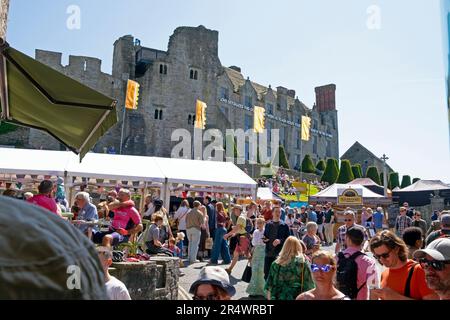 Blick auf die Burg von Hay vom Stadtzentrum während des Hay Festivals & Besucher, die die Messe auf dem Platz Hay-on-Wye, Wales Powys UK, 2023. Mai, KATHY DEWITT genießen Stockfoto