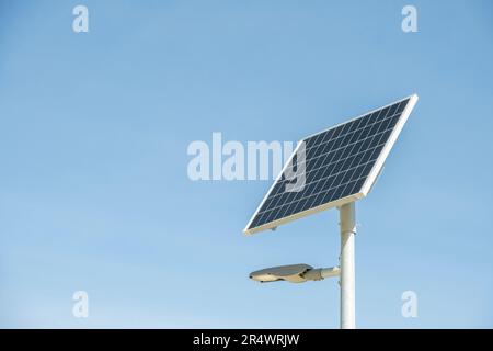 Öffentliche Stadtbeleuchtung mit Solarmodul in der Stadt. Straßenlaterne mit Solarpaneelenergie vor blauem Himmelshintergrund. Stange für Straßenbeleuchtung mit Stockfoto