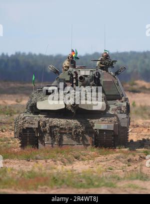 Pabrade, Litauen. 30. Mai 2023. Ein deutscher Leopard 2A6-Hauptkampfpanzer (vorn) und eine selbstfahrende Haubitze 2000 (hinten) gehen auf dem Trainingsgelände von Pabrade auf Position, während der deutsche Präsident Steinmeier die multinationale EFP-Kampfgruppe Litauen besucht. Die EFP (verstärkte Frontpräsenz) mit der Entsendung von vier Bataillonen soll die östliche Flanke der NATO in Estland, Lettland, Litauen und Polen stärken. Deutschland stellt den Kommandanten und derzeit rund 850 Soldaten auf dem litauischen Militärstützpunkt in Rukla zur Verfügung. Kredit: Soeren Stache/dpa/Alamy Live News Stockfoto