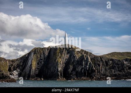 Das weiße, konische Baltimore Beacon im Dorf Baltimore auf der Klippe, das Seeschiffe vor der zerklüfteten Küste entlang der Atla schützt... Stockfoto