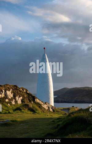 Das weiße, konische Baltimore Beacon im Dorf Baltimore bei Sonnenuntergang, das Seeschiffe vor der zerklüfteten Küste entlang des Atlantiks schützt... Stockfoto