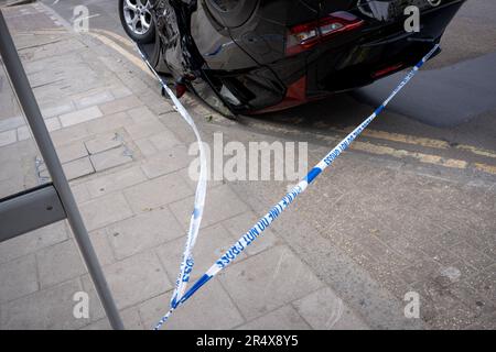 Das Polizeivideo umgibt die Folgen eines Autounfalls, bei dem ein umgestürzter Nissan-Heck an einer Bushaltestelle zwischen Brixton und Camberwell auf der Coldharbour Lane am 30. Mai 2023 in London, England, bleibt. Stockfoto