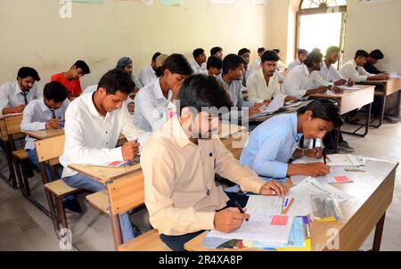 Studenten mit mittlerem Bildungsstand lösen Prüfungsunterlagen während der jährlichen Prüfung in einem Prüfungszentrum unter Aufsicht des Vorstands für mittlere und sekundäre Bildung in Hyderabad am Dienstag, den 30. Mai 2023. Stockfoto