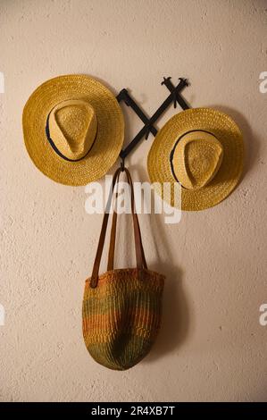 Zwei Hüte und ein Korb an einer Wand in einem Haus im Weinland; Portugal Stockfoto