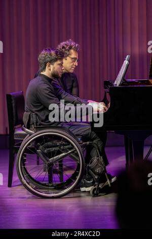 Ein körperlicher Konzertpianist spielt mit einem anderen Pianisten, der eine Rückenmarksverletzung hat: Edmonton, Alberta, Kanada Stockfoto