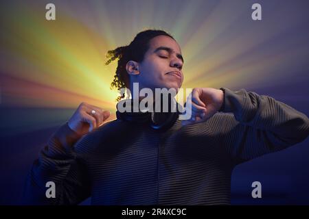 Porträt eines schwarzen jungen Mannes, der in Stroboskoplicht-Halo tanzt, auf einer Retro-Disco-Party Stockfoto