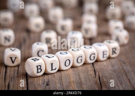 Das Wort Blog geschrieben auf Holzwürfel vor Computer-Tastatur Hintergrund. Konzept von Blog, Blogging oder Blogger. Stockfoto