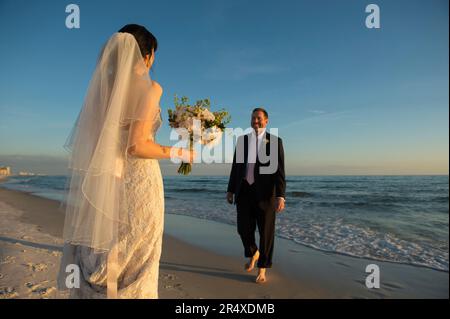 Braut und Bräutigam begrüßen sich an einem Strand in Florida, USA; Panama City Beach, Florida, USA Stockfoto