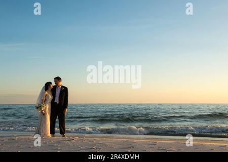 Braut und Bräutigam an einem Strand in Florida; Panama City Beach, Florida, Vereinigte Staaten von Amerika Stockfoto