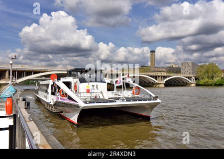 London Wandsworth Battersea blauer Himmel über der Themse und der Chelsea Bridge und ein Uber Boot thames Clipper, der am Coaling Jetty anlegt Stockfoto