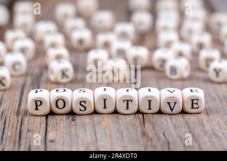 Motivierendes und inspirierendes Wort – POSITIV – positiv auf Holzblöcken geschrieben Stockfoto