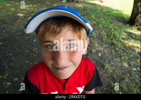 Vor seinem T-Ball-Spiel lächelt ein Junge im Alter von elementar vor der Kamera; Lincoln, Nebraska, USA Stockfoto