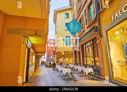 LUGANO, SCHWEIZ - 14. MÄRZ 2022: Kleine Außenterrasse des Restaurants in der engen Via Pessina in der Schweizer Altstadt Stockfoto