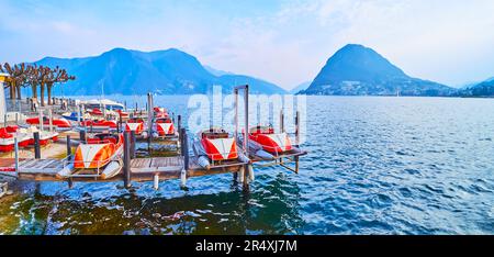 Panoramablick auf Ceresio mit klassischen Touristenkatamaranen auf dem Pier am Luganer See vor dem Monte San Salvatore, Lugano, Schweiz Stockfoto