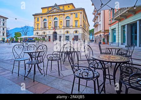 Die kleinen Tische und Stühle des Restaurants im Freien auf der Piazza della Riforma vor dem Palazzo Civico Gebäude, Lugano, Schweiz Stockfoto