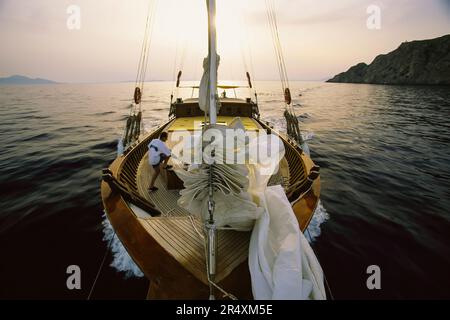 Mann, der die Segel auf einer Yacht senkt; Mittelmeer Stockfoto