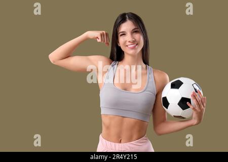 Sportliche junge Frau mit Fußball auf farbigem Hintergrund Stockfoto