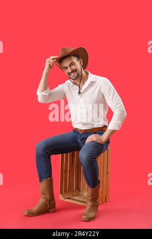 Hübscher Cowboy auf rotem Hintergrund Stockfoto