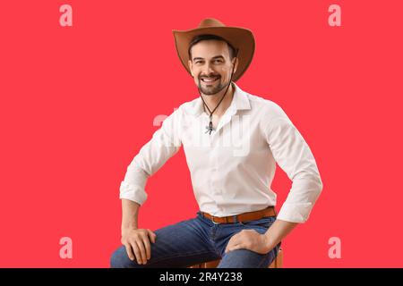 Hübscher Cowboy auf rotem Hintergrund Stockfoto