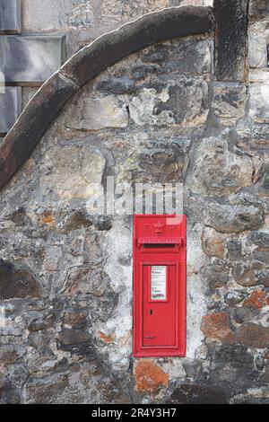 Ein klassischer, altmodischer, alter, roter Briefkasten oder Briefkasten, der von königlicher Post verwendet wird, in eine alte Steinmauer im historischen schottischen Dorf Aberdo eingebaut Stockfoto