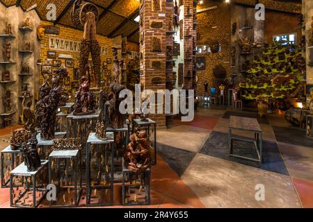 Holzschnitzereien aus der Werkstatt des Kungoni Centre of Culture and Art in Mua, Dedza, Malawi, darunter eine große Giraffen-Skulptur, füllen die verklinkerten Verkaufsräume; die Werkstatt beschäftigt heute mehr als 120 Holzschnitzer. Stockfoto