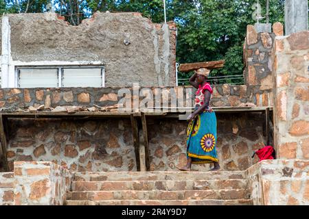 Bauarbeiten an einem Steinhaus in der Nähe von Lilongwe. Männer und Frauen arbeiten zusammen auf der Baustelle der Kumbali Country Lodge in Lilongwe, Malawi Stockfoto