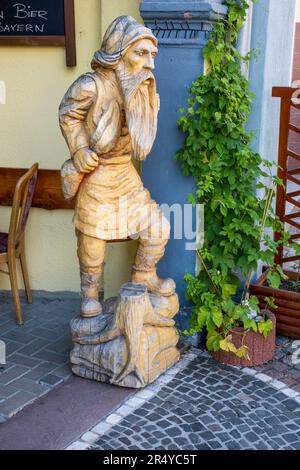 Holzschnitzerstatue vor einem Restaurant in der Marktstraße in der Altstadt, Rudesheim, Deutschland Stockfoto