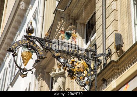 Wiesbaden, Deutschland - 18. Mai 2023: goldene Beschilderung an der Fassade eines alten Weinguts mit goldenen Trauben. Sie liefern auch Süßigkeiten. Stockfoto