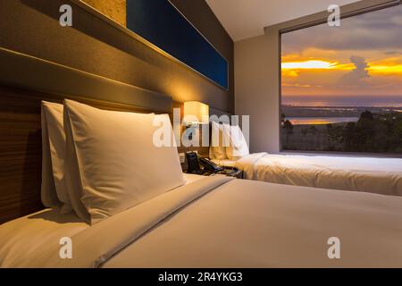 Minimalistisches Schlafzimmer mit Blick auf das Meer bei Sonnenuntergang. Stockfoto