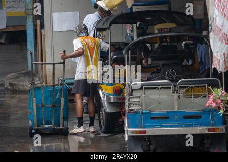 SAMUT PRAKAN, THAILAND, MAI 10 2023, Ein Spediteur von Einkäufen auf dem Markt steht in einem dreirädrigen Taxi Stockfoto