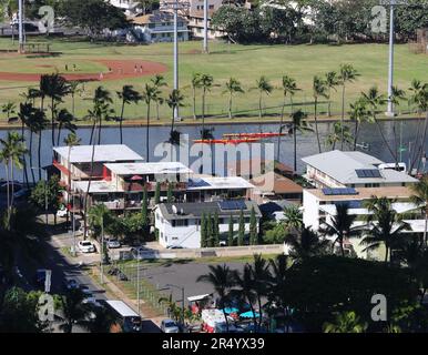 Honolulu, Hawaii, USA – 26. Mai 2023: Ruderfreunde auf dem Ala Wai Canal in leuchtend roten Outrigger-Kanus. Stockfoto