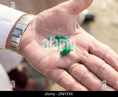 Ein Mann zeigt ein paar grobe, ungeschnittene Smaragde Kristalle in der Hand aus der Swat Smaragd-Mine in Pakistan Stockfoto
