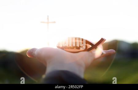 Heller Sonnenaufgang im neuen Jahr und christliches Symbol für Fische Formen Ichthys und jesus und Kirchenkreuz Stockfoto