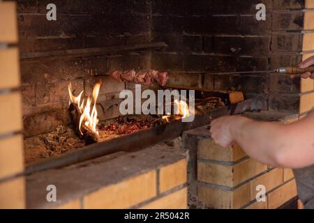 Marinierte Schaschlik vorbereiten auf ein Barbecue-Grill auf Holzkohle. Schaschlik oder Schaschlik in Osteuropa beliebt. Stockfoto