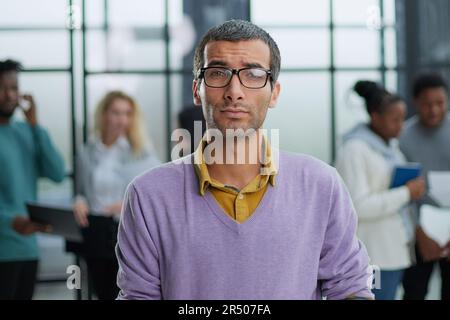 Der junge, gutaussehende Mann in eleganter Kleidung und Brille sieht weg Stockfoto