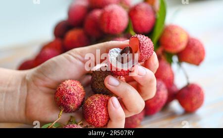 Litschis auf der Hand, frische, reife Lychee-Früchte tropische Früchte geschälte Litschis in Thailand Stockfoto