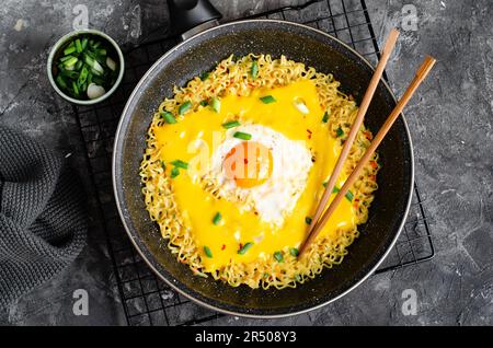 Kujirai Ramen, Shin Ramyeon oder Ramyun mit Ei, geschmolzenem Käse und Scallion, Instant Noodles auf dunklem Hintergrund Stockfoto