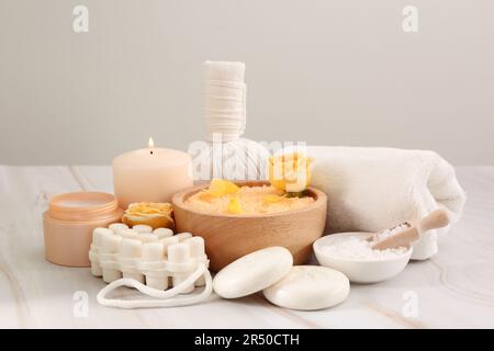 Meersalz, verschiedene Spa-Produkte und wunderschöne Rose auf weißem Marmortisch Stockfoto