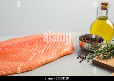 Frischer roher Lachs und Zutaten für Marinade auf grauem Tisch Stockfoto