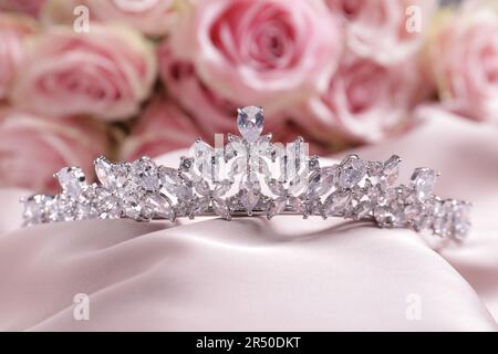 Wunderschönes silbernes Diadem mit Diamanten auf pinkfarbenem Seidentuch Stockfoto