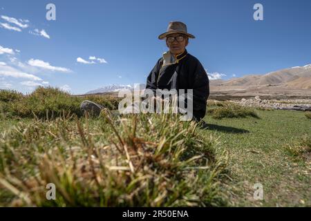 (230531) -- NGARI, 31. Mai 2023 (Xinhua) -- Losang Zhamdu sonnt sich auf einer Wiese vor seiner Residenz in Demqog Village, Zhaxigang Township, gar County in der Präfektur Ngari der Autonomen Region Tibet im Südwesten Chinas, 28. Mai 2023. Der 84-jährige Losang Zhamdu, der vor seiner Residenz im Dorf Demqog in der Stadt Zhaxigang, im Bezirk gar in der Präfektur Ngari in Tibet saß, erzählte eine Geschichte über die fünf Häuser, in denen er gelebt hatte.'Meine Mutter und ich lebten zusammen in einem Zelt aus Yakhaar, Alle unsere Besitztümer waren eine Ziegenfelljacke und eine abgenutzte tibetische Decke," erinnerte sich Losang Zhamdu, dann eine Leibeigenschaft, Stockfoto