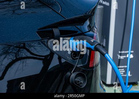 Hamburg, Deutschland - 05 04 2023: Verlegung eines Ladekabels an einem Elektroauto zum Laden der Batterie Stockfoto